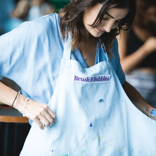 woman putting on art apron