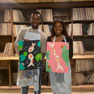 two people holding Koi fish paintings