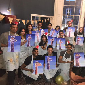 Birthday group pose for picture with their llama canvas paintings