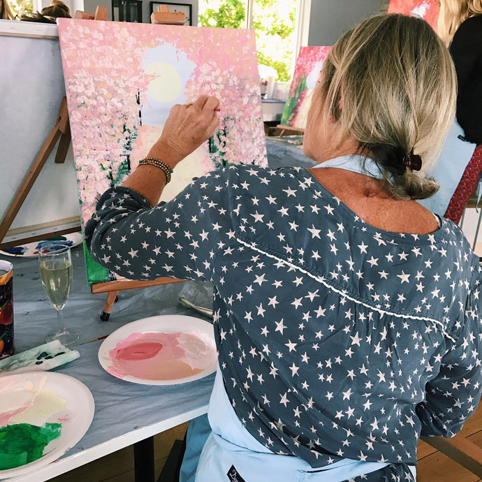 Women paints beautiful floral canvas painting
