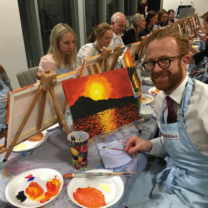Employee posing with his sunset seaside canvas painting 