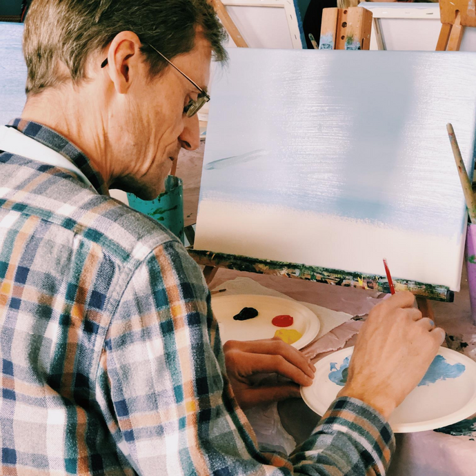 Man mixing paints for his step by step canvas painting